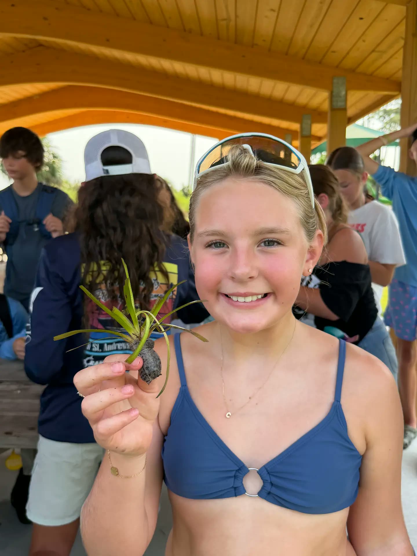 A camper holding a seagrass shoot ready for planting
