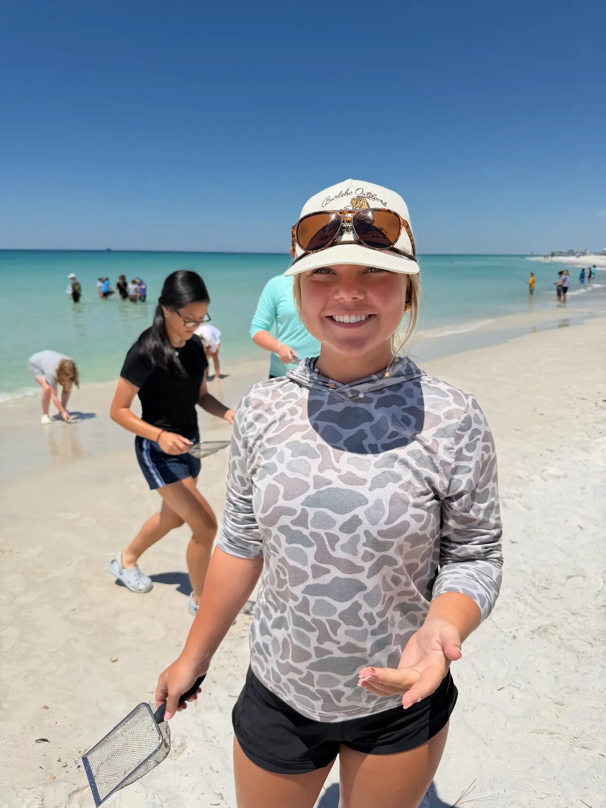 A student holding a dip net on the beach during a field adventure