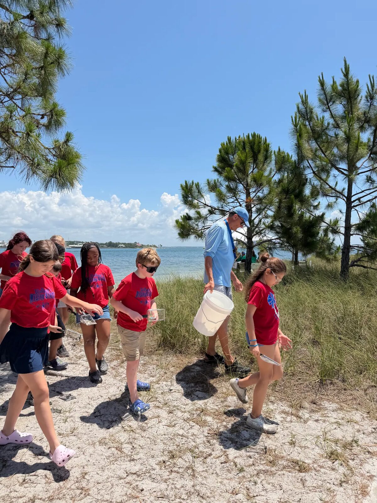 Students carrying dip nets and buckets to the sampling site