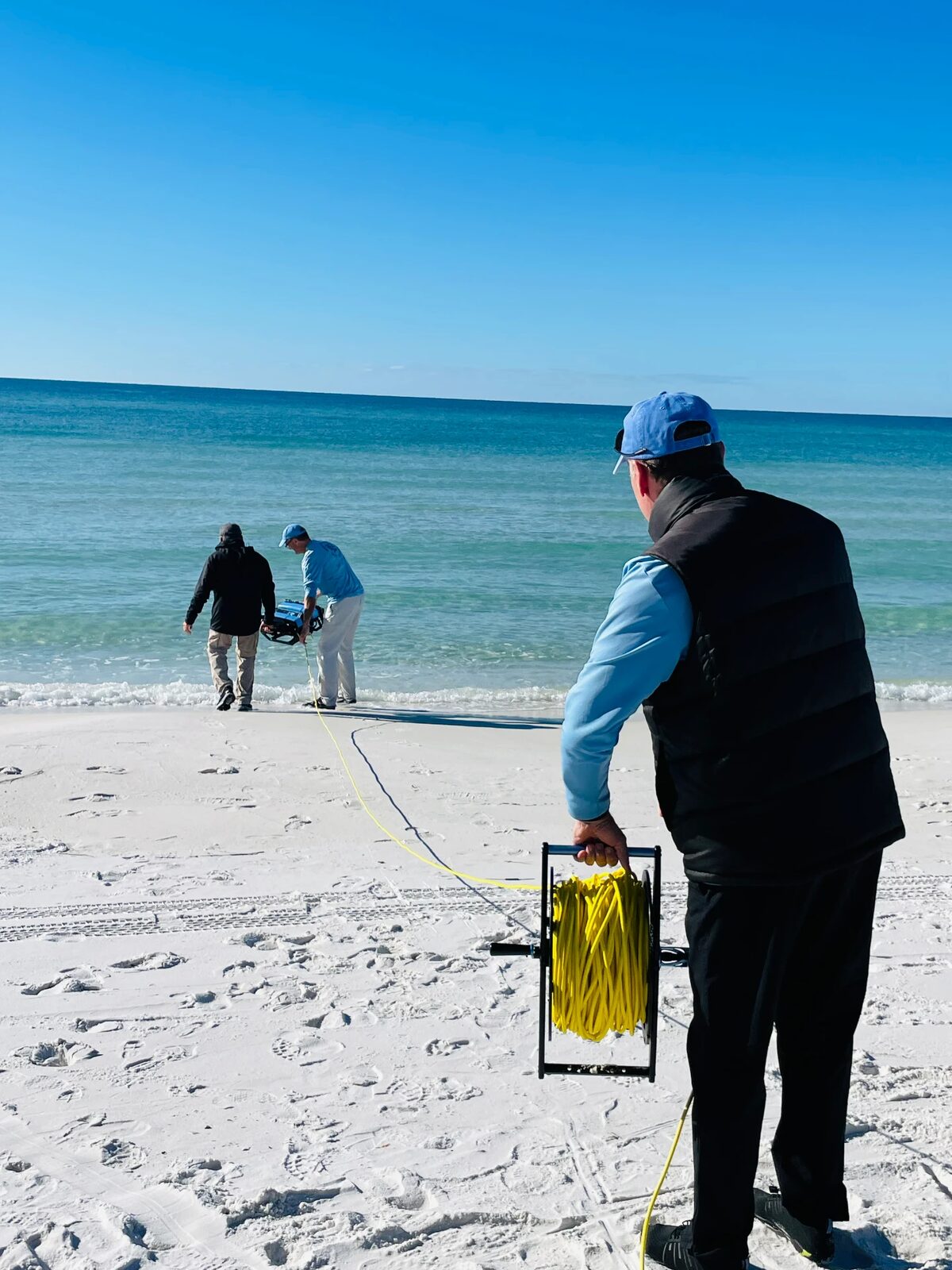 Educators launching an underwater ROV from the beach