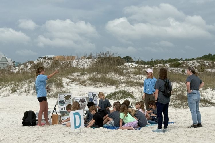 Educator teaching students about coastal dunes