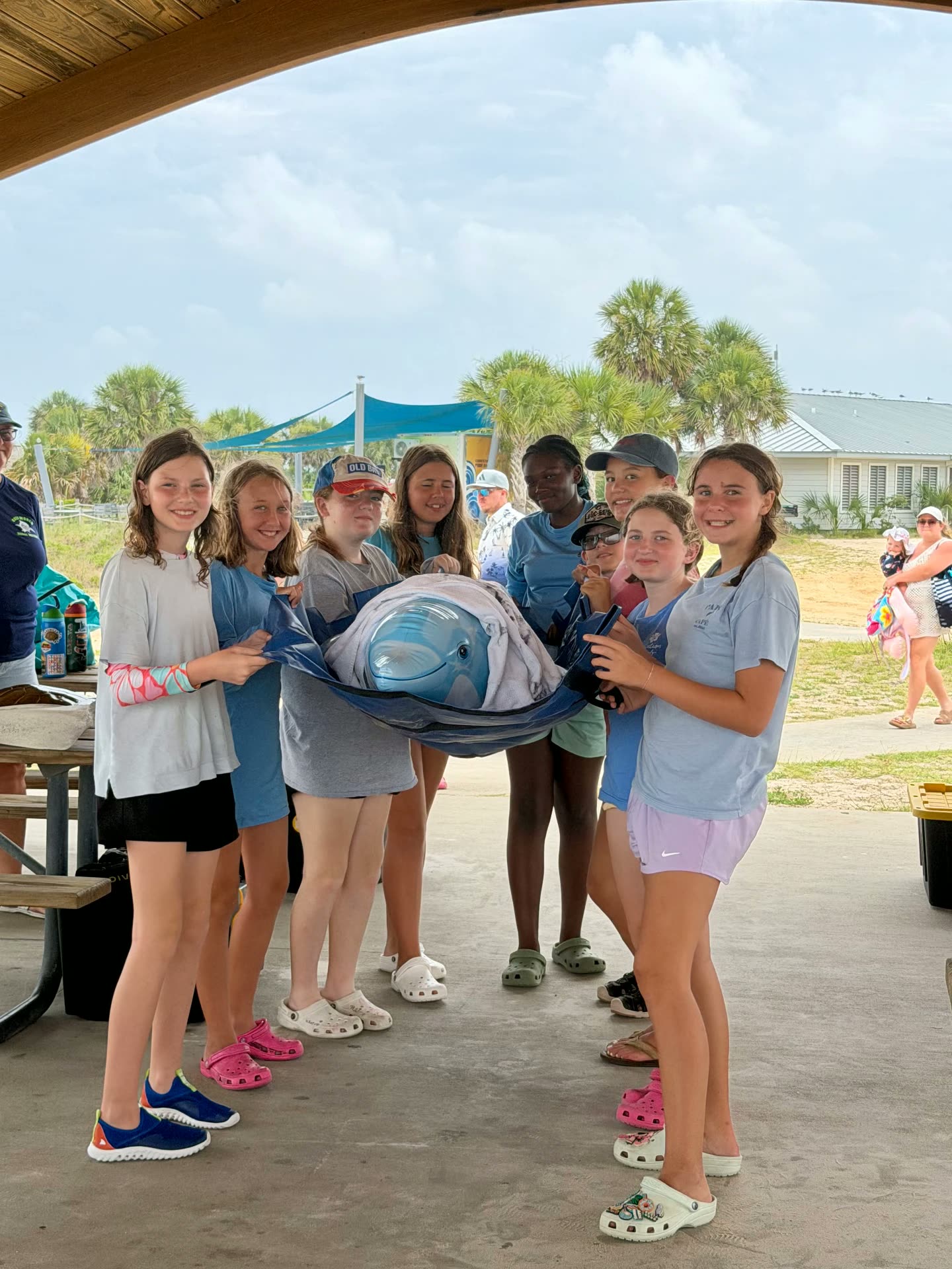 Campers holding a dolphin stretcher during a marine rescue demonstration