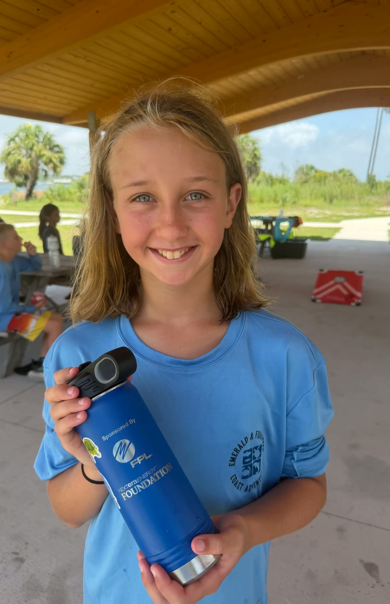A camper holding her sponsored camp water bottle
